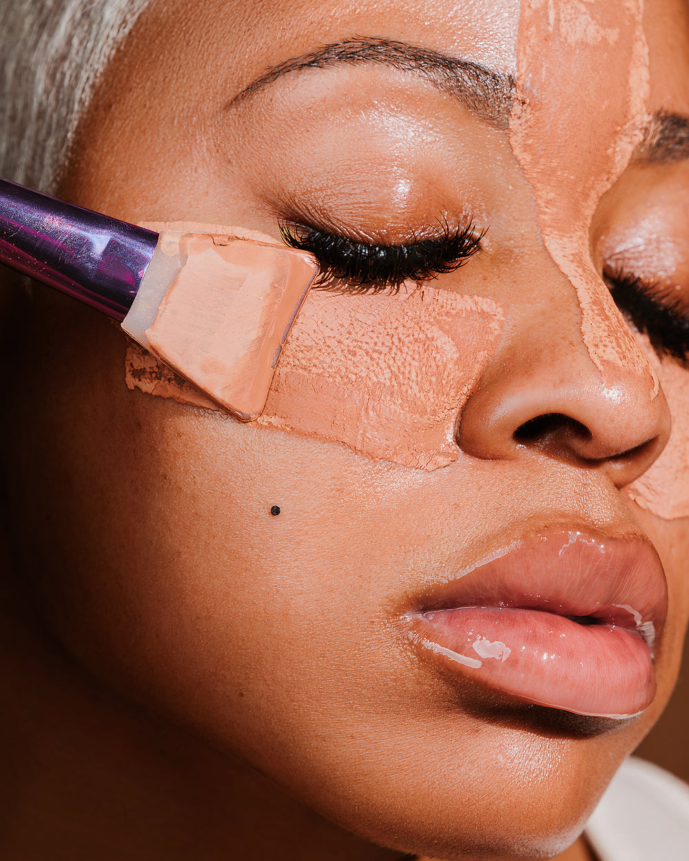 Faska skincare products including a jar, two bottles, and a spray bottle on a wooden tray with a blue background.